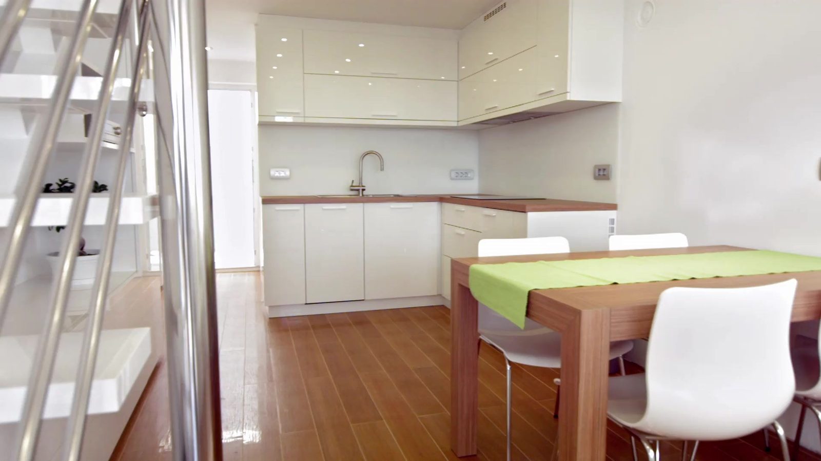 Bright white kitchen opening to a wood dining table